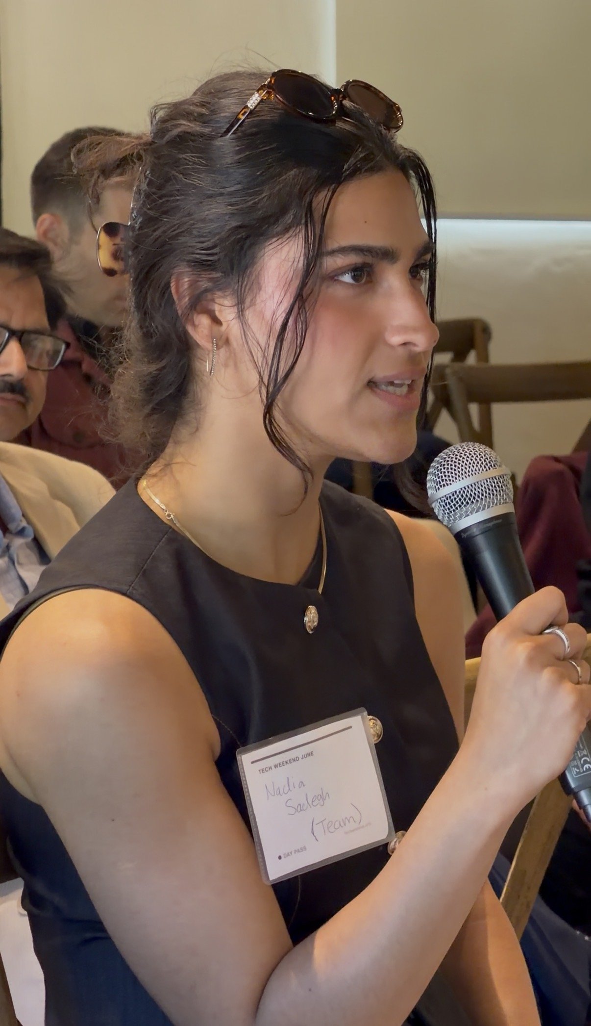 Nadia asking a question with a microphone at a tech event